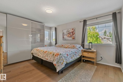 Wood-finish flooring throughout, complemented by a contemporary ceiling light fixture - 591 Byrne Crescent Sw, Edmonton, AB 
