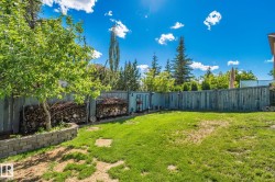 Expansive backyard featuring a partial grass lawn, mature trees, and a privacy fence - 