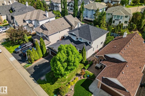 Asphalt shingle roofing, mature trees, landscaped grounds, paved driveway, and established neighborhood setting - 591 Byrne Crescent Sw, Edmonton, AB 