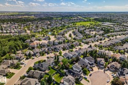 Residential community with varied architectural styles, mature trees, and a central green space with a pond - 