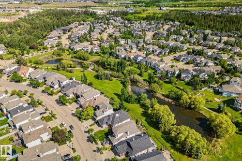 Established residential area featuring detached homes, tree-lined streets, and green spaces with natural water features - 591 Byrne Crescent Sw, Edmonton, AB 