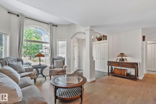 Arched window, wood-finish flooring, white paneled doors, and an arched entry - 591 Byrne Crescent Sw, Edmonton, AB 