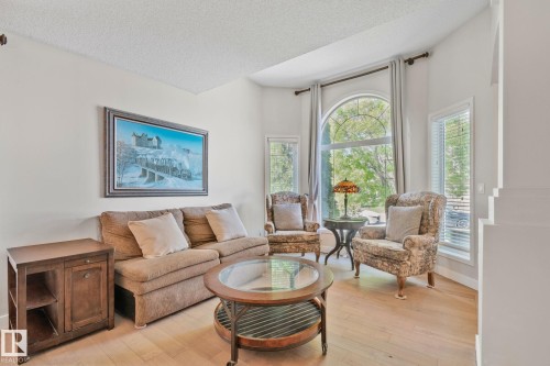 Vaulted ceiling, arched picture window, wood-finish flooring, and white painted walls - 591 Byrne Crescent Sw, Edmonton, AB 