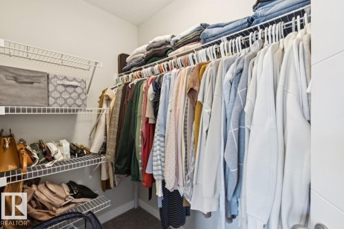 Primary bedroom walk-in closet - #13 600 Bellerose Dr, St. Albert, AB - Indoor With Storage
