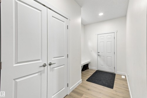 Recessed lighting, light wood-finish flooring, white panel doors, white trim, and a built-in bench - 107 Ellice Bend, Fort Saskatchewan, AB 