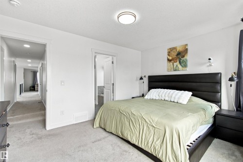 Recessed lighting in hallway, white interior doors, and neutral carpeting - 107 Ellice Bend, Fort Saskatchewan, AB 