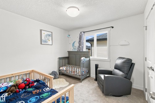 Recessed ceiling light fixture, white interior walls, framed window, textured ceiling, and carpet flooring - 107 Ellice Bend, Fort Saskatchewan, AB 