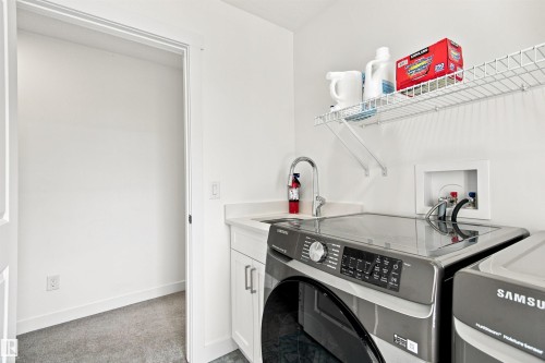 White cabinetry with polished hardware, integrated sink, and chrome faucet - 107 Ellice Bend, Fort Saskatchewan, AB 