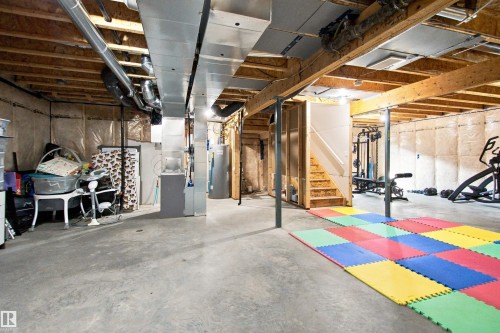 Unfinished basement with concrete flooring, exposed wood joists, and visible ductwork - 107 Ellice Bend, Fort Saskatchewan, AB 