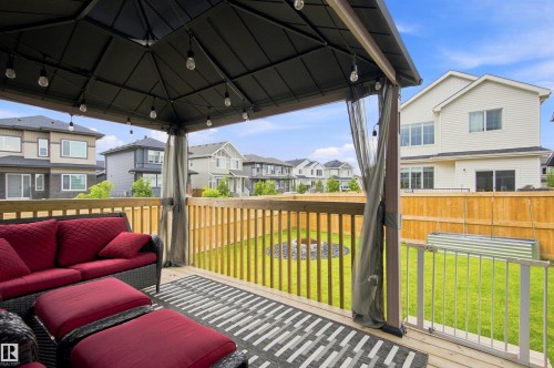 Expansive wood deck with a built-in gazebo, string lighting, and direct access to the backyard - 107 Ellice Bend, Fort Saskatchewan, AB 