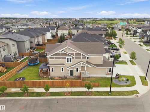 Two-story property with a corner lot, fenced backyard, exterior with light-colored siding, attached garage, and landscaping at the front - 107 Ellice Bend, Fort Saskatchewan, AB 