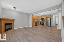 Wood-finish flooring throughout, featuring a gas fireplace with a wood mantel - 