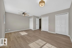 Wood-finish flooring, neutral wall tones, ceiling fan, flush mount lighting, and white bi-fold doors - 