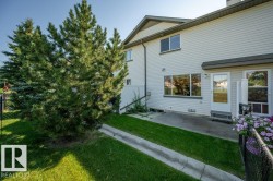 Exterior featuring horizontal siding, multiple windows, a rear entry door, and concrete patio - 