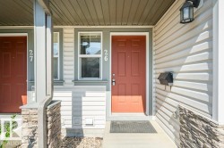 Entryway featuring a panel door, decorative outdoor lighting fixture, and stone veneer accents - 