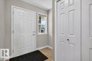 Entryway featuring a paneled door, wood-finish flooring, and a white framed window - #26 2816 34 Av Nw, Edmonton, AB 