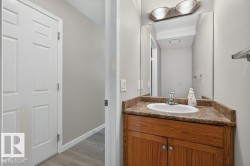 Wood-finish vanity with an integrated basin, a patterned countertop, and an overhead vanity light fixture - 