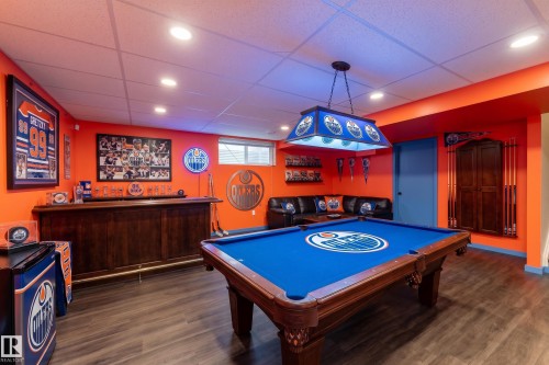 Game room featuring wood-finish flooring, recessed lighting, a built-in wet bar, and a billiard table with an overhead light fixture - 10820 178 Avenue Nw, Edmonton, AB 