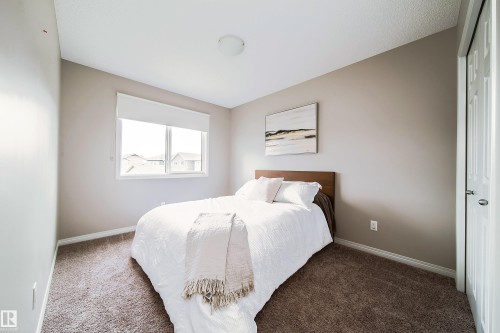 Plush carpet flooring, a large window with white trim, and a flush-mount ceiling light fixture - 3211 Cherry Crescent Sw, Edmonton, AB 