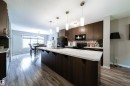Kitchen featuring dark wood-finish cabinetry, white countertops, stainless steel sink, and pendant lighting - 3211 Cherry Crescent Sw, Edmonton, AB 