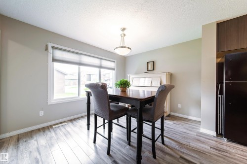 Wood-finish flooring, recessed lighting, and a large window with roller shades - 3211 Cherry Crescent Sw, Edmonton, AB 