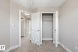Bedroom featuring light gray wall paint, white trim, and neutral carpeting - 