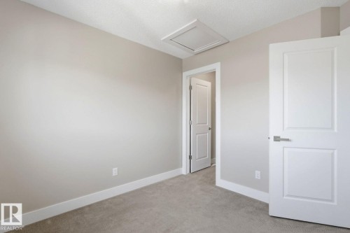 Neutral-toned walls complementing plush carpet flooring - 206 Southfork Drive, Leduc, AB - Indoor Photo Showing Other Room