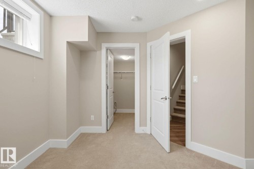 Carpeted room with neutral wall paint, white trim, a window with blinds, and white interior doors - 206 Southfork Drive, Leduc, AB - Indoor Photo Showing Other Room
