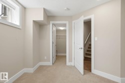 Carpeted room with neutral wall paint, white trim, a window with blinds, and white interior doors - 