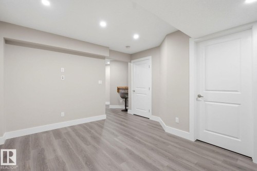 Open-concept interior featuring wood-finish flooring, recessed lighting, neutral wall tones, and white trim - 206 Southfork Drive, Leduc, AB - Indoor Photo Showing Other Room