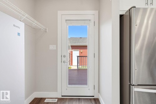 Full-lite exterior door with integrated blinds opening onto an outdoor deck - 206 Southfork Drive, Leduc, AB - Indoor Photo Showing Other Room