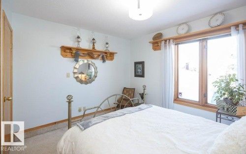 Light-toned walls, wood-trimmed window, a decorative wood shelf, and light-colored carpet flooring - 11007 108 Avenue, Westlock, AB 