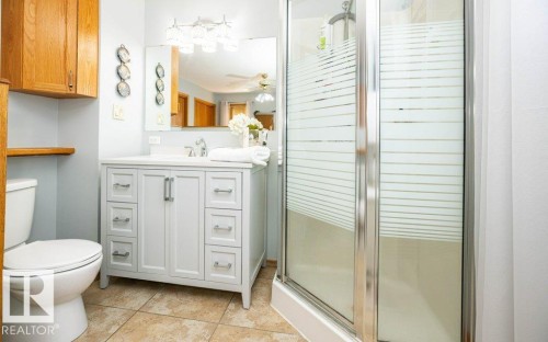 White vanity with chrome hardware, an integrated sink, and a framed mirror - 11007 108 Avenue, Westlock, AB 