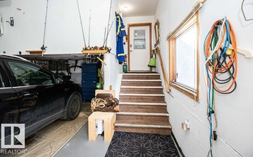 Attached garage with concrete flooring, built-in shelving, interior access door, and a single window - 11007 108 Avenue, Westlock, AB 