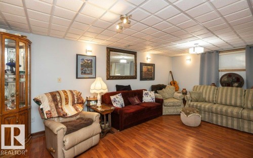 Wood-finish flooring throughout, complemented by a drop ceiling with recessed lighting - 11007 108 Avenue, Westlock, AB 