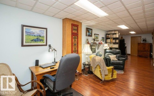Recessed panel ceiling, wood-finish flooring, built-in shelving, and warm wall colors - 11007 108 Avenue, Westlock, AB 