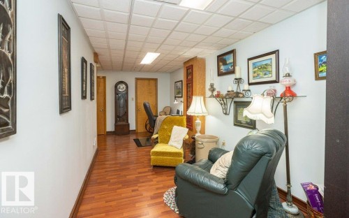 Wood-finish flooring with a drop ceiling featuring recessed lighting - 11007 108 Avenue, Westlock, AB 