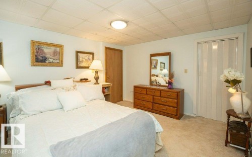 Carpeted flooring, paneled ceiling, wood-finish door, and compact accordion-style closet door - 11007 108 Avenue, Westlock, AB 