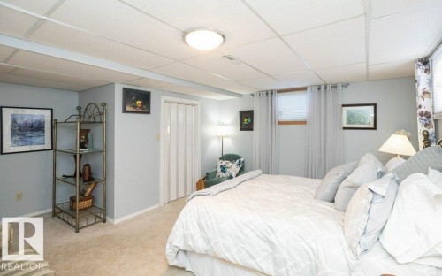 Carpeted flooring, drop ceiling with recessed lighting, and a window with blinds - 11007 108 Avenue, Westlock, AB 