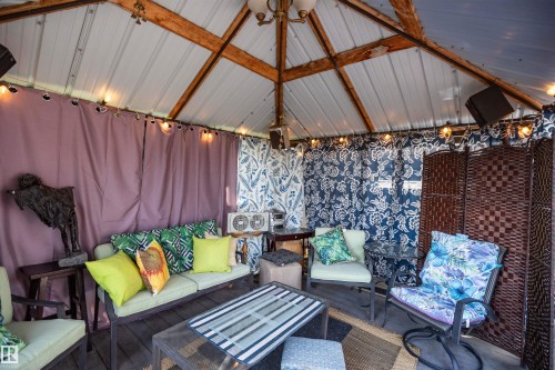 Vaulted metal ceiling with exposed wood beams, featuring a central light fixture - 11007 108 Avenue, Westlock, AB 