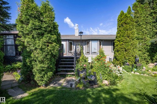 Manicured lawn with mature evergreen trees and a stone pathway - 11007 108 Avenue, Westlock, AB 