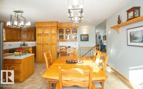 Kitchen with wood-finish cabinetry, white countertops, and a central island - 11007 108 Avenue, Westlock, AB 