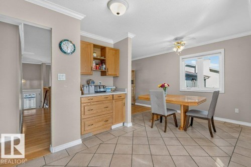 Kitchenette with wood-finish cabinetry, white countertop, and tile flooring - 14527 32 Street Nw, Edmonton, AB 