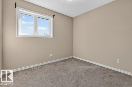 Neutral tone wall paint, window with white trim, recessed ceiling lighting, and carpet flooring - 14527 32 Street Nw, Edmonton, AB 
