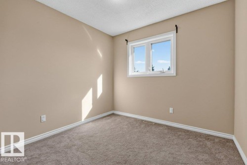 Neutral-toned walls, gray carpeting, and a white-framed window - 14527 32 Street Nw, Edmonton, AB 