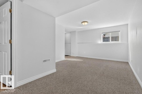 Neutral paint palette with a modern semi-flush mount light fixture - 14527 32 Street Nw, Edmonton, AB 