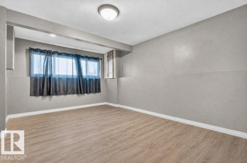 Neutral wall color, wood-finish flooring, white trim, and ceiling-mounted light fixture - 14527 32 Street Nw, Edmonton, AB 