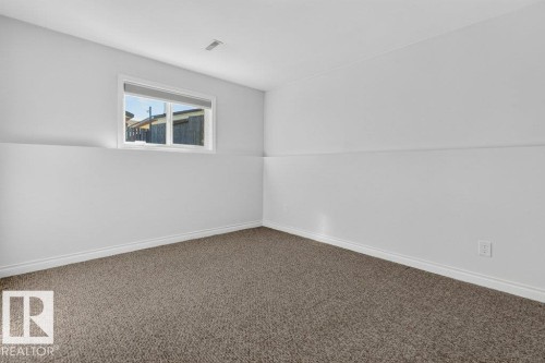 Carpeted flooring, white painted walls, and a window with a roller shade - 14527 32 Street Nw, Edmonton, AB 