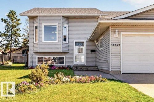 Siding exterior with a bay window feature, attached garage, and a peaked roofline - 14527 32 Street Nw, Edmonton, AB 