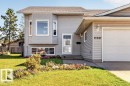 Siding exterior with a bay window feature, attached garage, and a peaked roofline - 14527 32 Street Nw, Edmonton, AB 